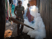 A worker is spraying pesticide to kill mosquitoes as a preventive measure against Dengue fever in a densely populated residential area in Dh...