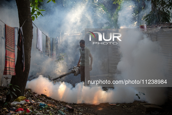 A worker is spraying pesticide to kill mosquitoes as a preventive measure against Dengue fever in a densely populated residential area in Dh...