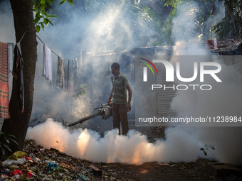 A worker is spraying pesticide to kill mosquitoes as a preventive measure against Dengue fever in a densely populated residential area in Dh...