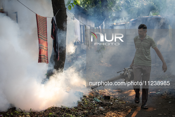 A worker is spraying pesticide to kill mosquitoes as a preventive measure against Dengue fever in a densely populated residential area in Dh...