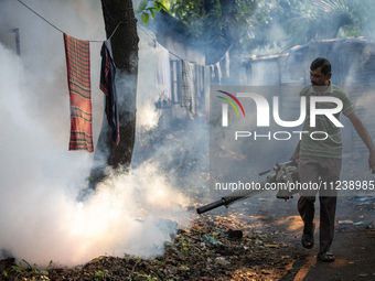 A worker is spraying pesticide to kill mosquitoes as a preventive measure against Dengue fever in a densely populated residential area in Dh...