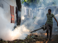 A worker is spraying pesticide to kill mosquitoes as a preventive measure against Dengue fever in a densely populated residential area in Dh...