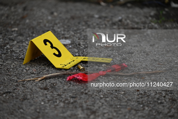 A shell casing is being seen next to an evidence marker at the crime scene. Two people are being shot in Chicago, Illinois, United States, o...