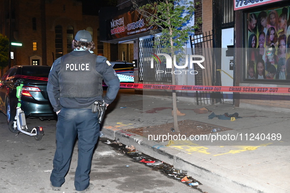 A police officer is standing watch as evidence on the ground, consisting of footwear, clothes, and blood, is seen at the crime scene. A 33-y...