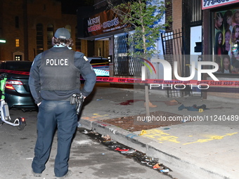 A police officer is standing watch as evidence on the ground, consisting of footwear, clothes, and blood, is seen at the crime scene. A 33-y...