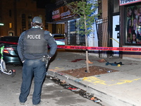 A police officer is standing watch as evidence on the ground, consisting of footwear, clothes, and blood, is seen at the crime scene. A 33-y...