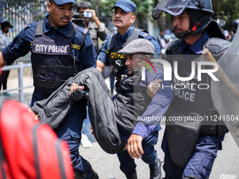 Nepal Police are arresting a differently able person as they protest in Kathmandu, Nepal, on May 15, 2024. (