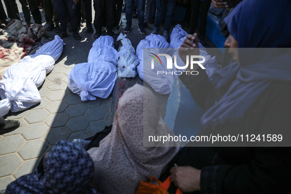 Palestinians are mourning their relatives, killed in an overnight Israeli strike on the Al-Breij refugee camp, during a mass funeral at the...