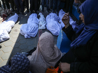 Palestinians are mourning their relatives, killed in an overnight Israeli strike on the Al-Breij refugee camp, during a mass funeral at the...