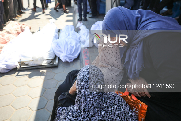 Palestinians are mourning their relatives, killed in an overnight Israeli strike on the Al-Breij refugee camp, during a mass funeral at the...