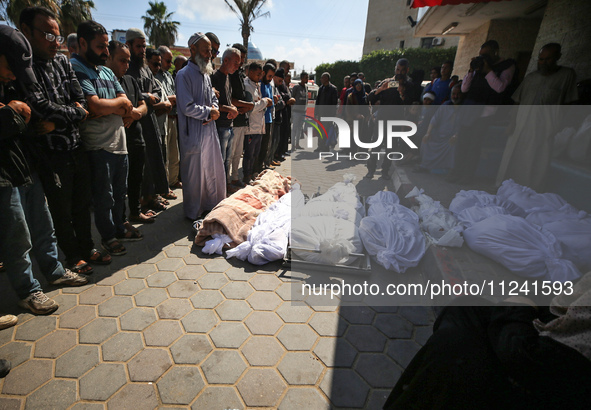 Palestinians are mourning their relatives, killed in an overnight Israeli strike on the Al-Breij refugee camp, during a mass funeral at the...