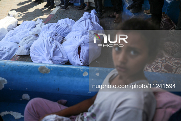 Palestinians are mourning their relatives, killed in an overnight Israeli strike on the Al-Breij refugee camp, during a mass funeral at the...