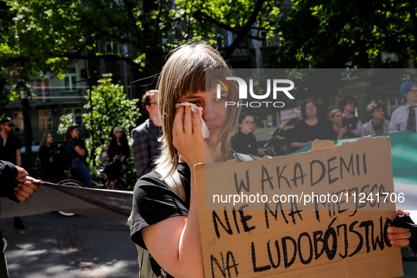 A student shows emotions and holds anti-genocide banner during academia demonstration against Israeli actions being taken in the Gaza Strip...