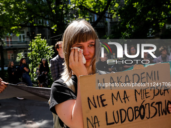 A student shows emotions and holds anti-genocide banner during academia demonstration against Israeli actions being taken in the Gaza Strip...