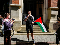 Organisers peak and hold Palestinian flags and banners during academia demonstration against Israeli actions being taken in the Gaza Strip i...