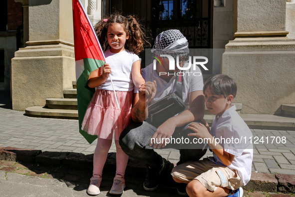 Palestinian family hold Palestinian flags as they attend academia demonstration against Israeli actions being taken in the Gaza Strip in fro...