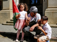 Palestinian family hold Palestinian flags as they attend academia demonstration against Israeli actions being taken in the Gaza Strip in fro...