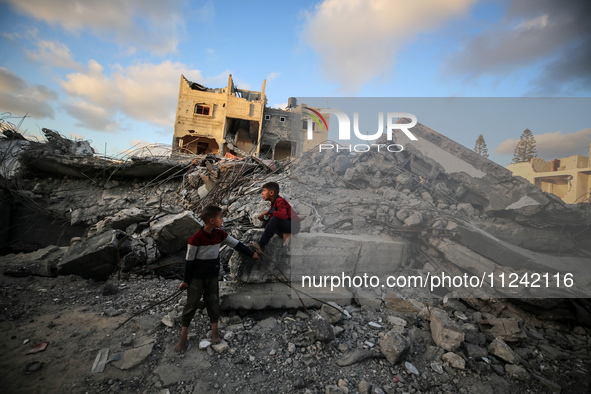 Palestinian children are checking a building destroyed by Israeli bombardment in Deir el-Balah in the central Gaza Strip on May 15, 2024, am...