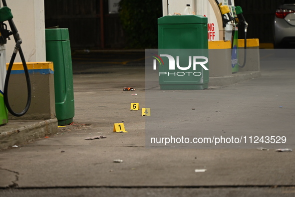 Evidence markers are being placed on the ground where shell casings are being discovered at the crime scene where a 35-year-old male is bein...