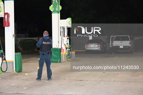 Evidence markers are being placed on the ground where shell casings are being discovered at the crime scene where a 35-year-old male is bein...