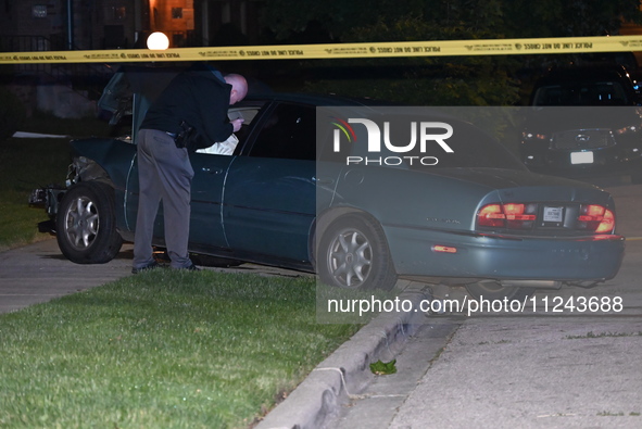 A Chicago police officer is looking over a vehicle involved in the crime scene. A 38-year-old male victim is being shot multiple times while...