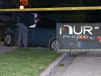 A Chicago police officer is looking over a vehicle involved in the crime scene. A 38-year-old male victim is being shot multiple times while...