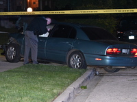 A Chicago police officer is looking over a vehicle involved in the crime scene. A 38-year-old male victim is being shot multiple times while...