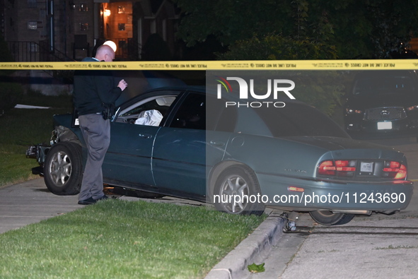 A Chicago police officer is looking over a vehicle involved in the crime scene. A 38-year-old male victim is being shot multiple times while...