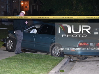 A Chicago police officer is looking over a vehicle involved in the crime scene. A 38-year-old male victim is being shot multiple times while...