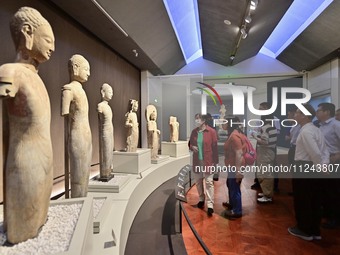 Visitors are looking at a cultural relics exhibition at Qingzhou Museum in East China's Shandong province, on May 16, 2024. (