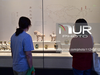 Visitors are looking at a cultural relics exhibition at Qingzhou Museum in East China's Shandong province, on May 16, 2024. (