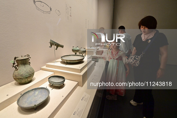 Visitors are looking at a cultural relics exhibition at Qingzhou Museum in East China's Shandong province, on May 16, 2024. 