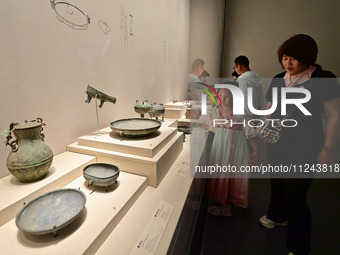 Visitors are looking at a cultural relics exhibition at Qingzhou Museum in East China's Shandong province, on May 16, 2024. (