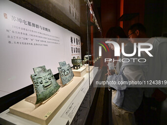 Visitors are looking at a cultural relics exhibition at Qingzhou Museum in East China's Shandong province, on May 16, 2024. (