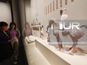 Visitors are looking at a cultural relics exhibition at Qingzhou Museum in East China's Shandong province, on May 16, 2024. (