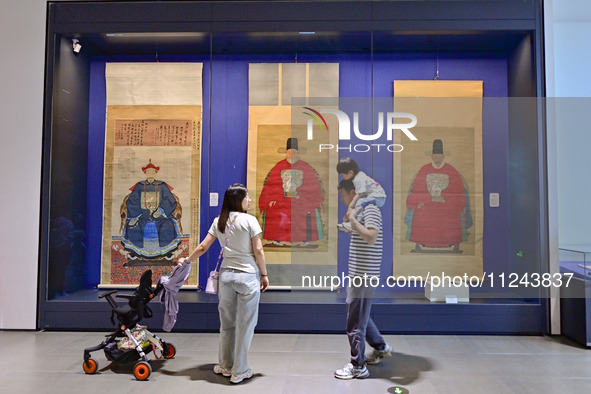 Visitors are looking at a cultural relics exhibition at Qingzhou Museum in East China's Shandong province, on May 16, 2024. 