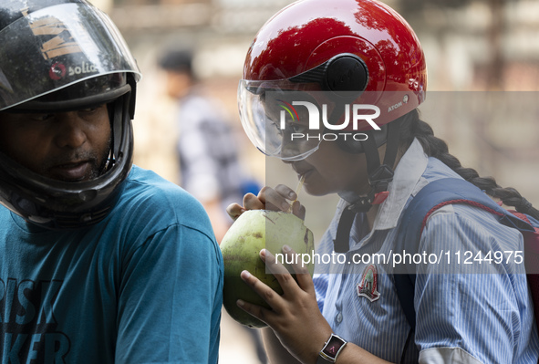 People are drinking coconut water along the roadside on a hot summer day in Guwahati, Assam, India, on May 16, 2024. Coconut water is natura...