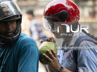 People are drinking coconut water along the roadside on a hot summer day in Guwahati, Assam, India, on May 16, 2024. Coconut water is natura...