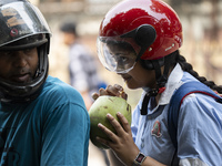 People are drinking coconut water along the roadside on a hot summer day in Guwahati, Assam, India, on May 16, 2024. Coconut water is natura...