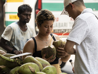 People are drinking coconut water along the roadside on a hot summer day in Guwahati, Assam, India, on May 16, 2024. Coconut water is natura...