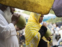 People are drinking coconut water along the roadside on a hot summer day in Guwahati, Assam, India, on May 16, 2024. Coconut water is natura...