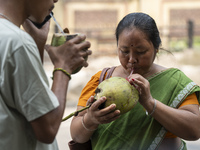 People are drinking coconut water along the roadside on a hot summer day in Guwahati, Assam, India, on May 16, 2024. Coconut water is natura...