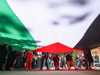 Students and activists hold a huge Palestinian flag during  solidarity with Palestine demonstration in front of Jagiellonian University buil...