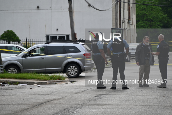 Police officers are gathering on the scene. A 26-year-old male victim is injured in a shooting in Chicago, Illinois, United States, on May 1...