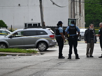 Police officers are gathering on the scene. A 26-year-old male victim is injured in a shooting in Chicago, Illinois, United States, on May 1...