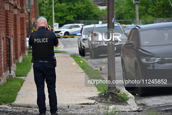 A police officer is photographing evidence at the crime scene. A 26-year-old male victim is injured in a shooting in Chicago, Illinois, Unit...