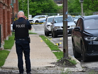 A police officer is photographing evidence at the crime scene. A 26-year-old male victim is injured in a shooting in Chicago, Illinois, Unit...