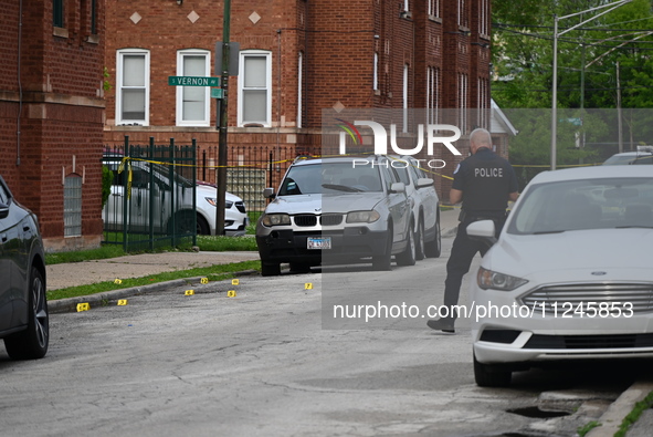 A police officer is photographing evidence at the crime scene. A 26-year-old male victim is injured in a shooting in Chicago, Illinois, Unit...