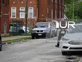 A police officer is photographing evidence at the crime scene. A 26-year-old male victim is injured in a shooting in Chicago, Illinois, Unit...