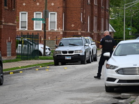 A police officer is photographing evidence at the crime scene. A 26-year-old male victim is injured in a shooting in Chicago, Illinois, Unit...